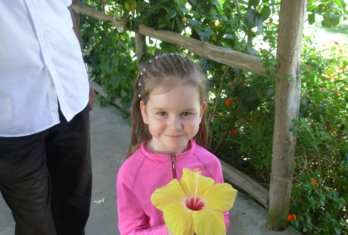 Sydney waiting in line for food at Scotchies Ocho Rios Jamaica with flower in hand