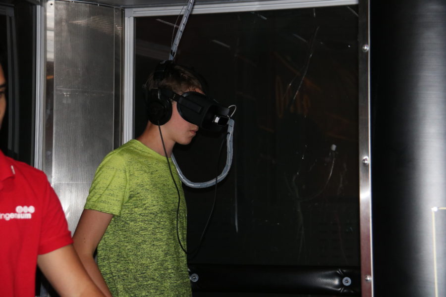 Lucas wearing goggles and using the virtual reality booth at the museum