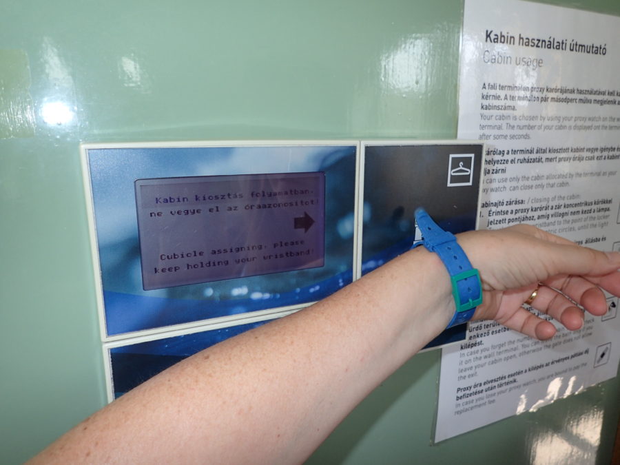 image of arm with wristband touching the led screen to open a cabin at Szechenyi Baths
