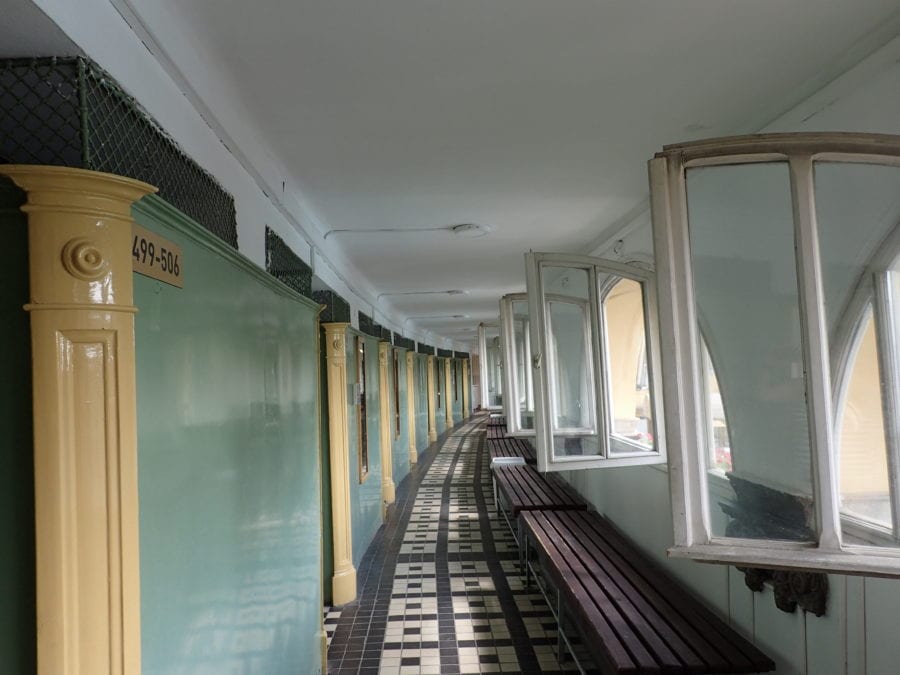 hallway at Szechenyi Baths with windows to the right and doors to cabins on the left