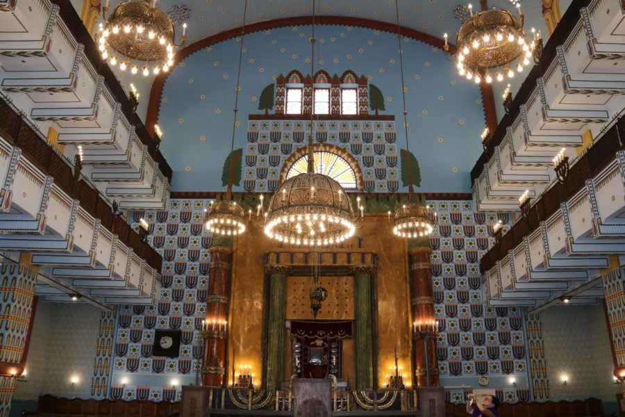 Great Budapest activities include visit interior of Kazinczy Synagogue include bright chandeliers and bright white and blue painted interior