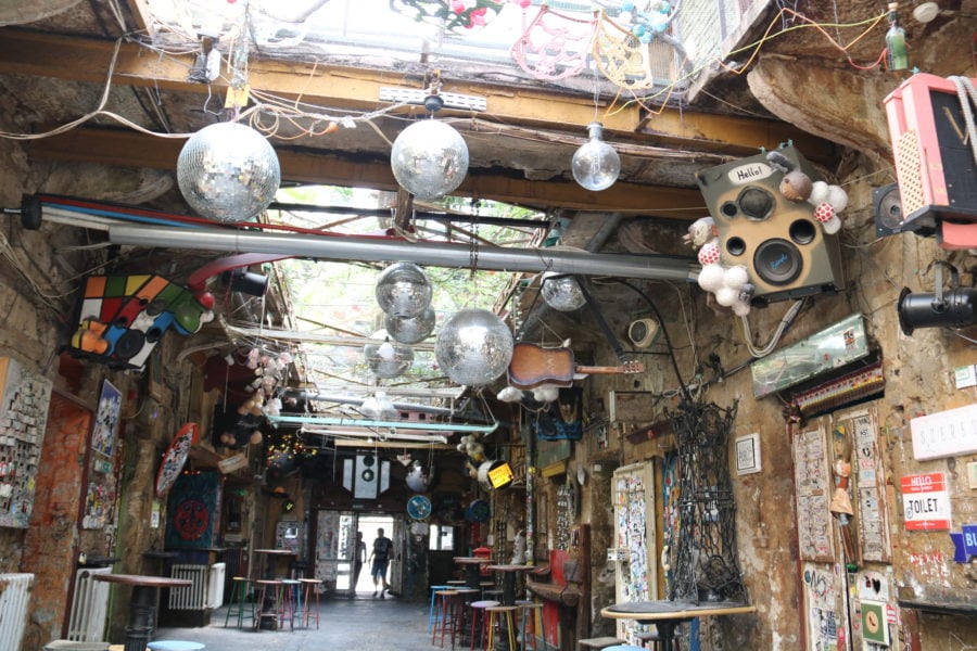image of us in Budapest with kids exploring interior of ruin pub with silver disco balls hanging from ceiling