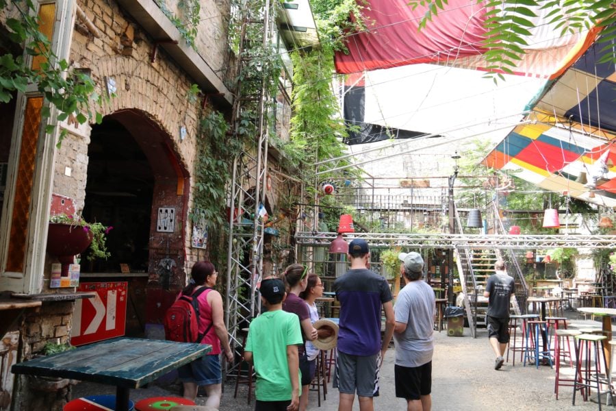 image of main floor of Szimpla Kert with open air ceiling and rustic furnishings