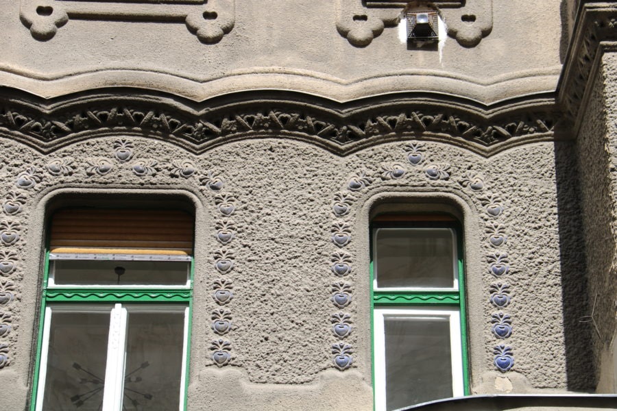 image taken on Budapest private tour of two windows with blue flowers around them