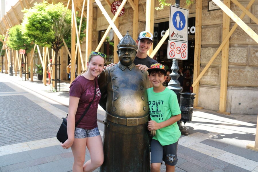 image of our kids in Budapest next to brass policeman