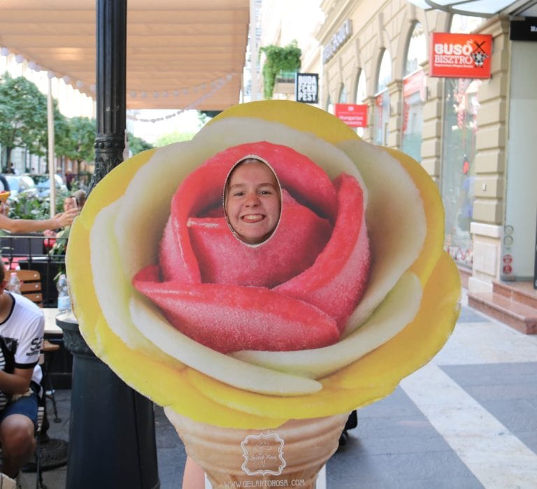 Sydney with her face in the cutout of a life size cardboard ice cream cone at Gelarto Rosa Budapest