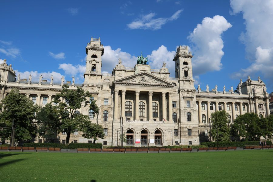 image of a large white building of beautiful architecture with statue on top