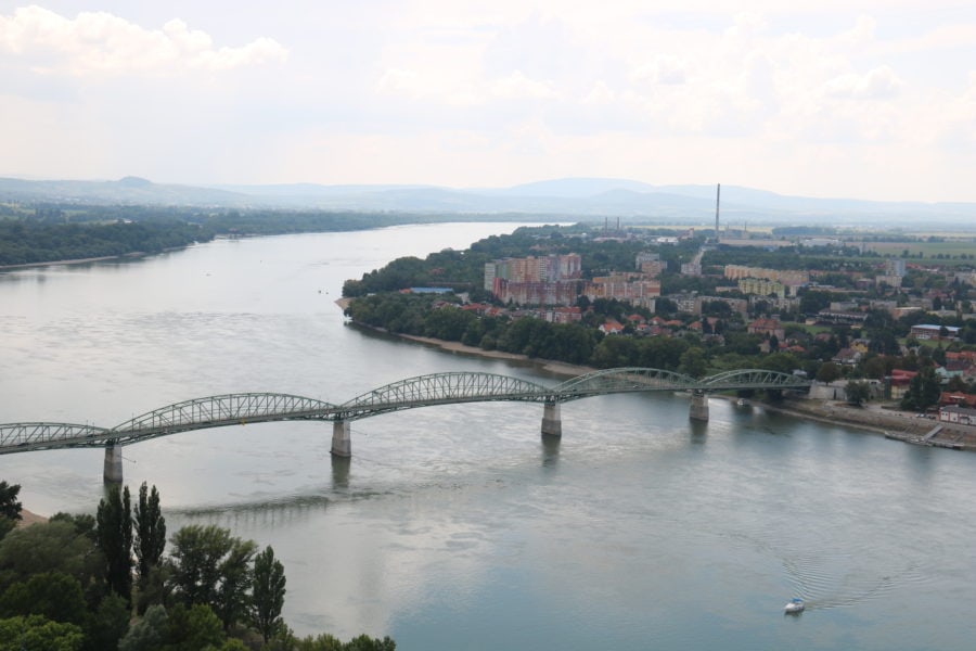 image of green arched bridge of Danube River with city in Slovakia on other side