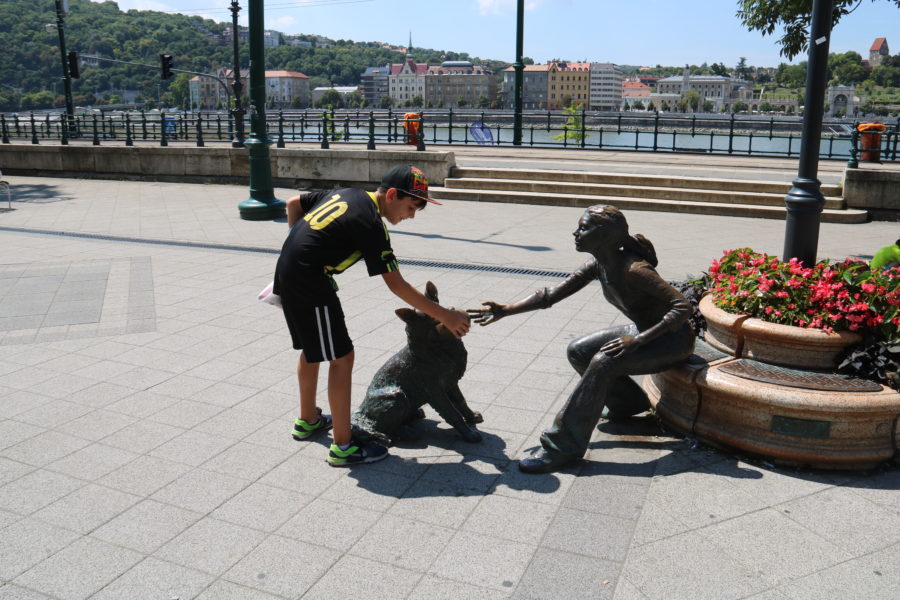 image of Caiden with a statue of girl and dog