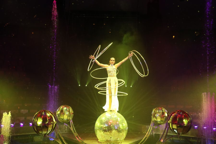 image of woman on ball with 10+ hula hoops spinning
