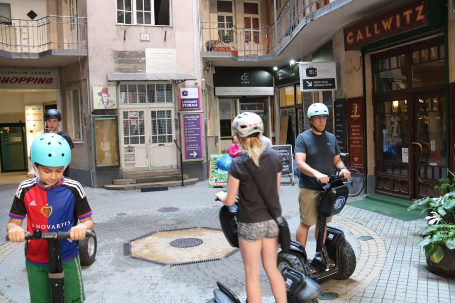 image of family in courtyard practicing driving the segways