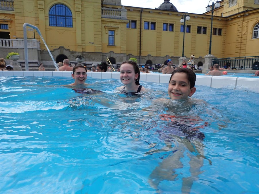 image of my three kids in Budapest floating in water of Szechenyi baths