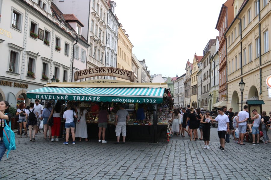 image of market stalls with green awning stating havelske trziste market Prague is fun thing to do in Prague