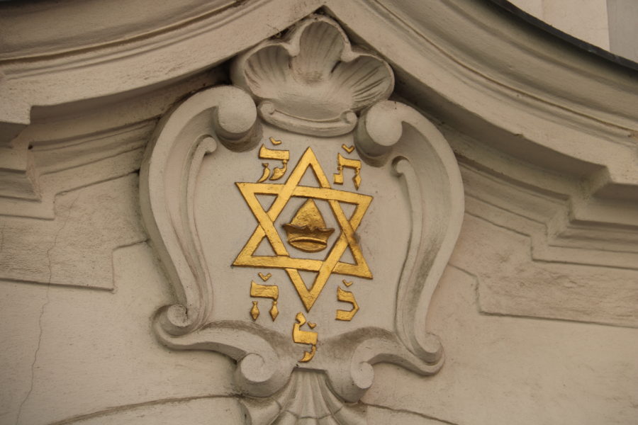 image of gold guilded star of David on white building in Prague
