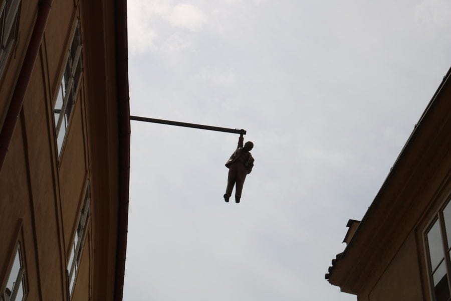 image of Sigmund Freud hanging by one hand from a pole extending over the street from three stories above is fun thing to do in Prague