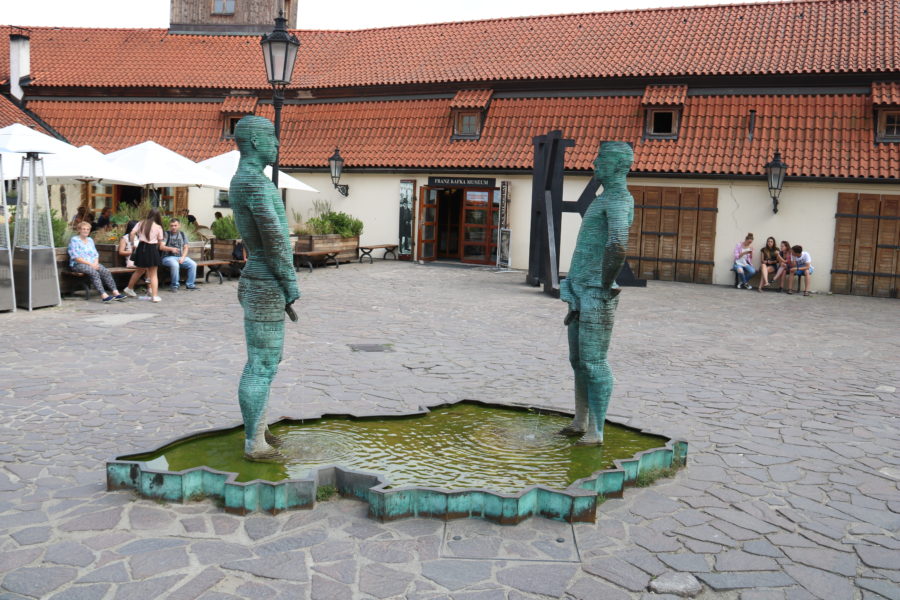 image of two green men fully clothed but peeing into a pool shaped like the Czech Republic
