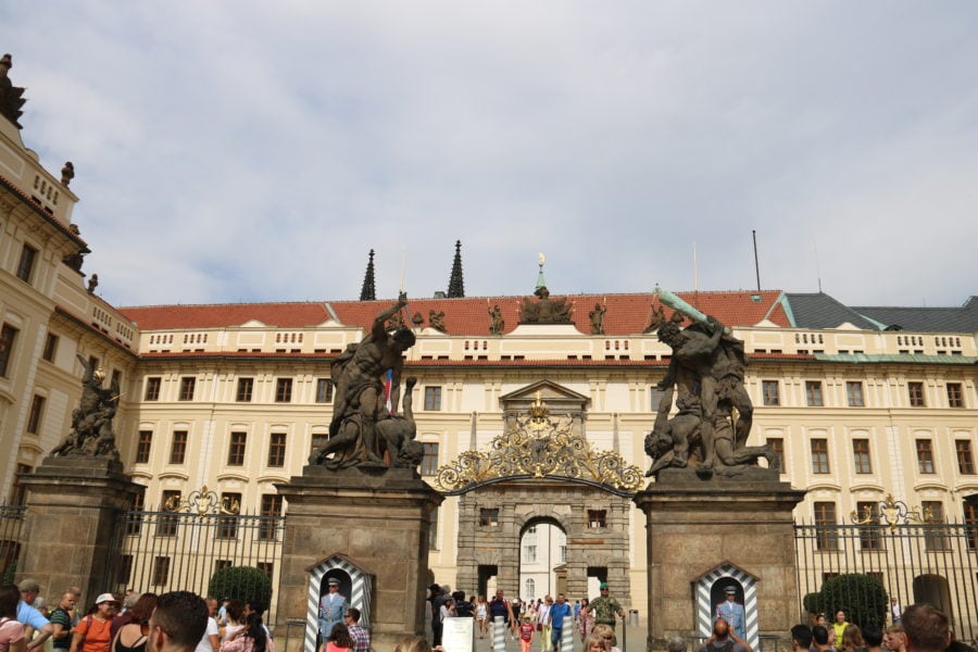 image of castle with two arches in front standing two soldiers in light blue and is a fun thing for kids to do in Prague