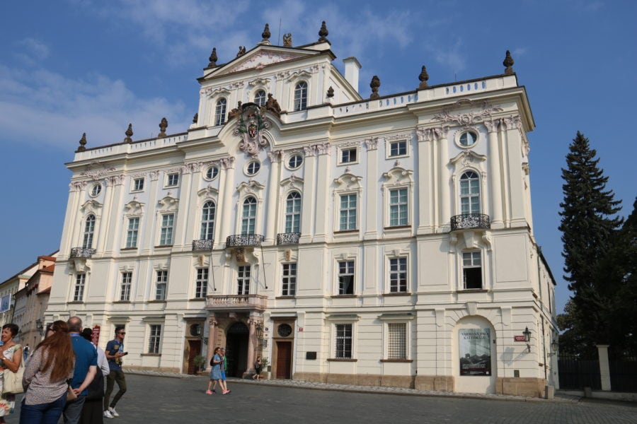 image of large four story regal building with crest in center towards roof best Prague sights