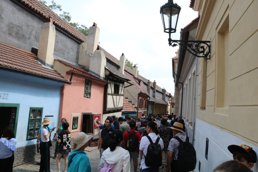 image of very full cobble stone street with small colourful cottages along the side