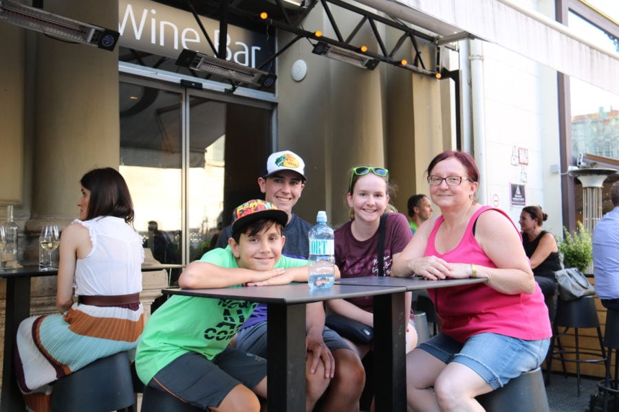 image of kids and Heidi sitting at a tall table outdoors at wine bar