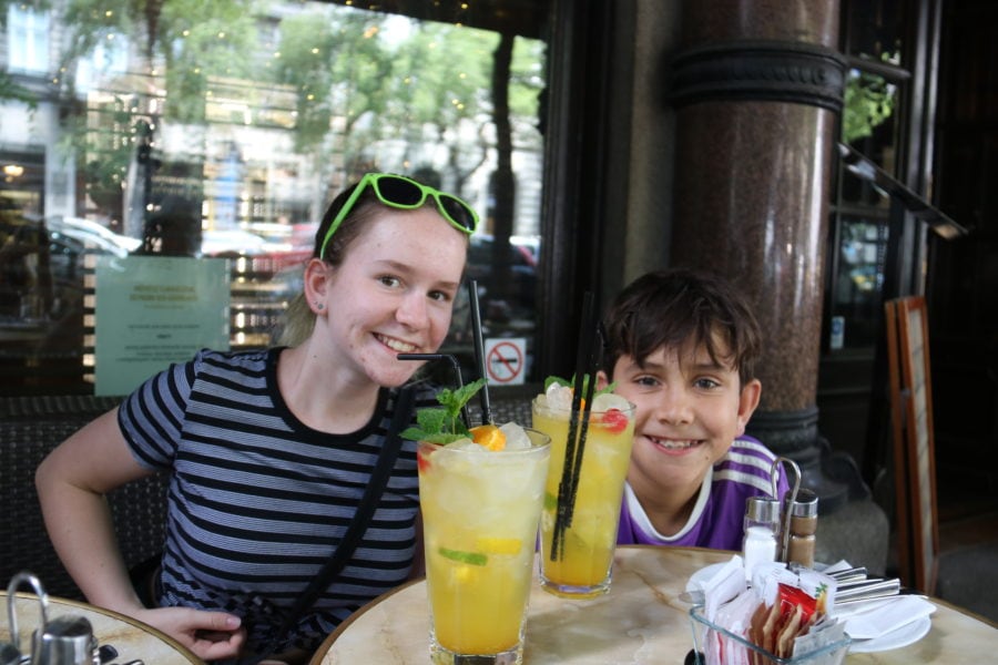 image of Sydney and Caiden drinking mango lemonade at outdoor table on day 2 of Budapest Itinerary