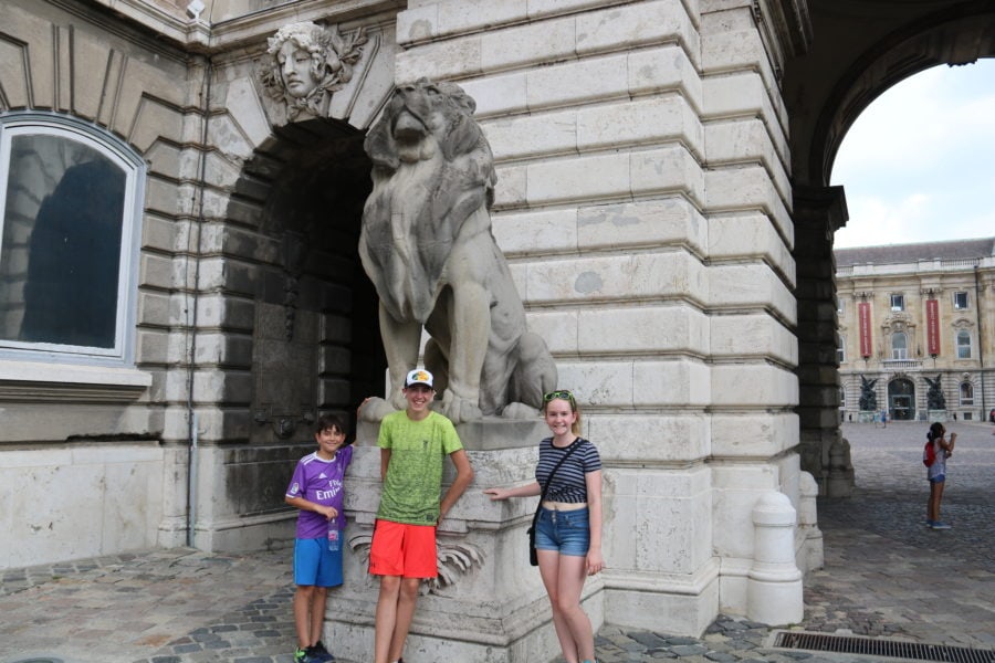Image of my kids standing in front of stone lion
