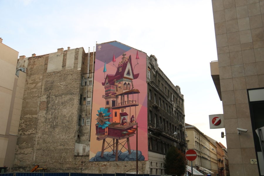image of large pink birdhouse painted on wall in Budapest