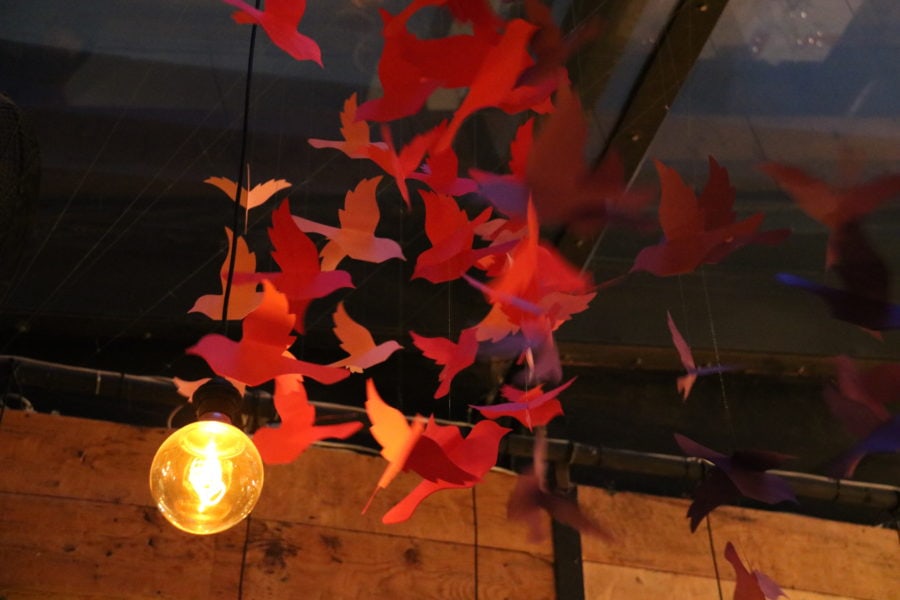 image of red paper birds hanging from ceiling