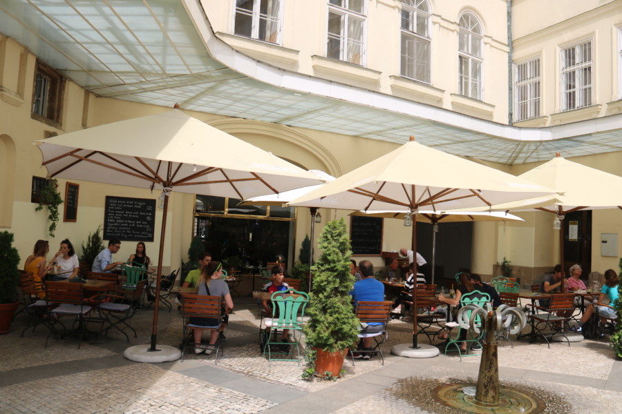 image of cafe for lunch with white umbrellas in courtyard day 2 of 3 days in Prague Itinerary