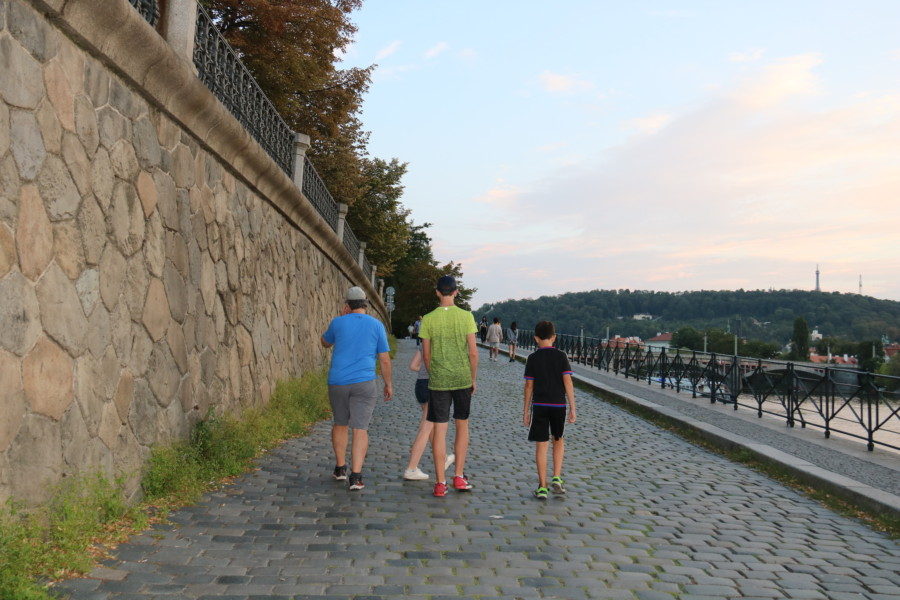 image of us walking along cobblestone path next to river 3 days in Prague intinerary