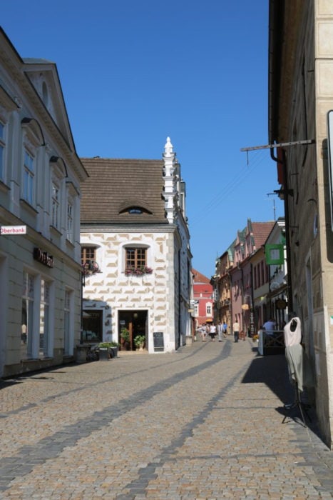 image of cobblestone street with beautiful buildings along the side visit Tabor, Czech Republic