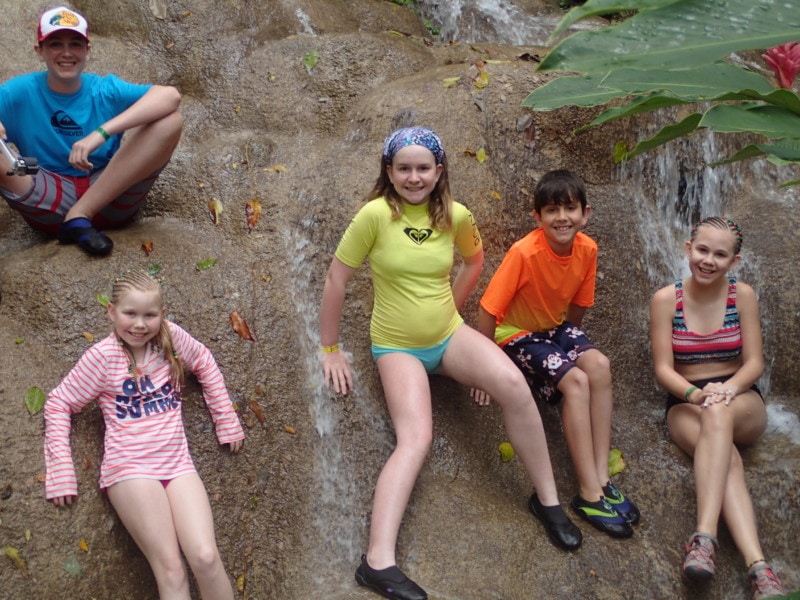 kids leaning on a rock in Konoko Falls things to do in Jamaica