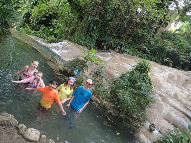 Kids standing in a small pool of water at top of falls things to do Jamaica