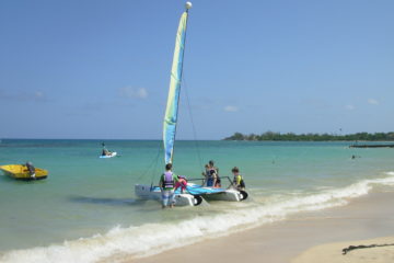 kids on beach with catamaran Jamaica Jewel Runaway Bay Resort