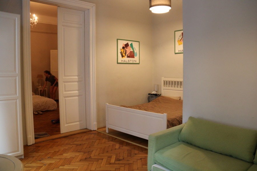 double bed in room with green couch in Budapest family apartment