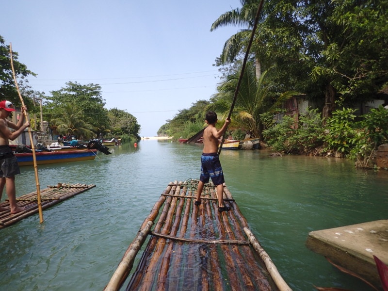 my two boys steering the rafts with large bamboo poles off the beaten path Jamaica
