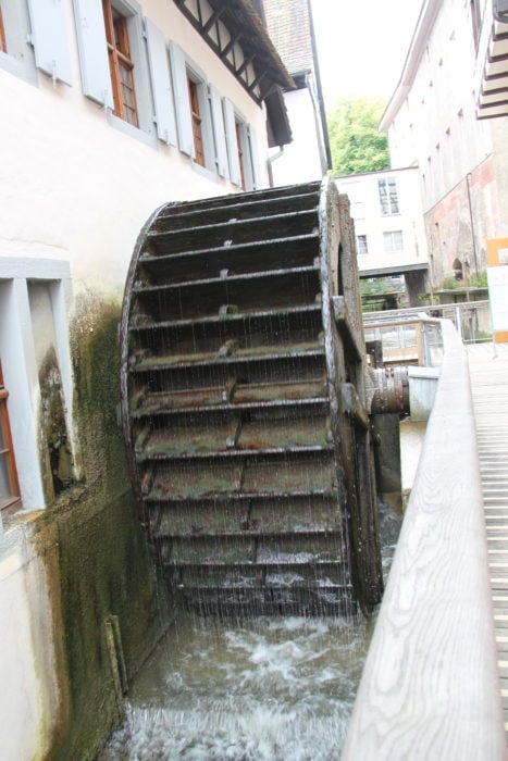large water wheel still operating with water at Papermill Museum in Basel