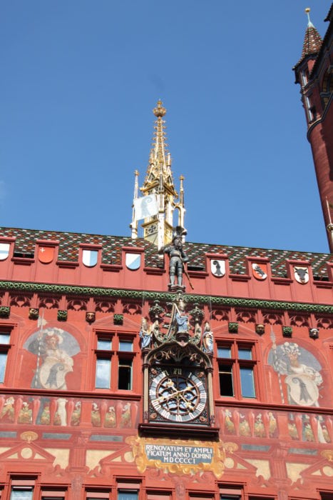 red majestic building with gold steeple and paintings one of best sights to see in Basel Switzerland