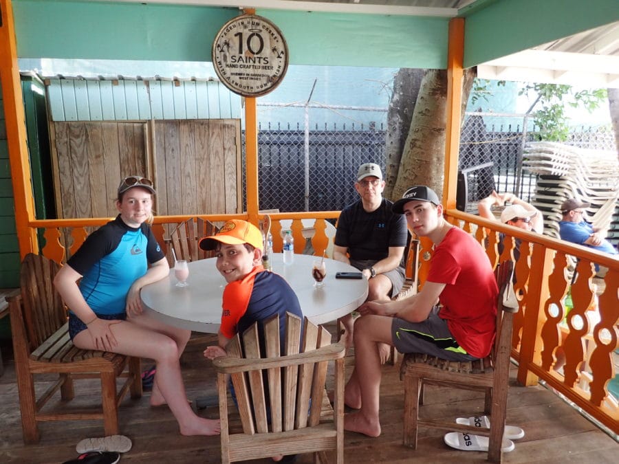 my family sitting around table on deck at beach bar