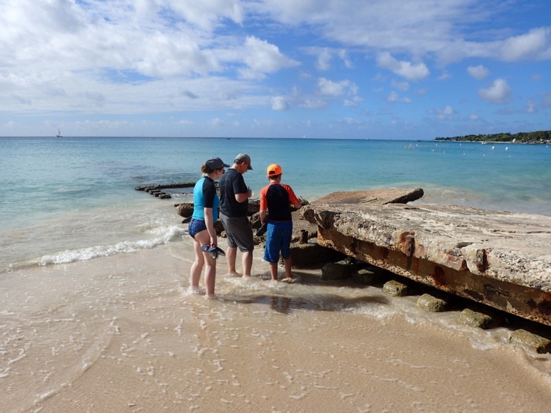 Barbados attraction of my family leaning over dock looking for crabs in the crevices