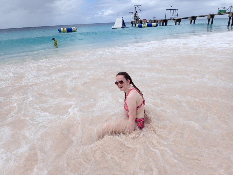 Sydney sitting in water and then waves crashing on top of her at Boatyard beach Bridgetown 