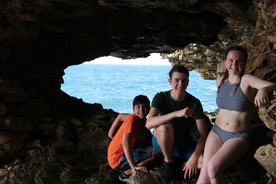 my three kids leaning on cave walls with open window to sea behind them is amazing instagram photo of Barbados