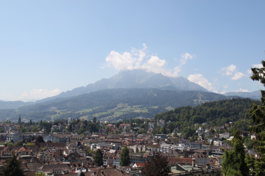 distant view of large mountain over the top of the orange roof city of Lucerne is Mount Pilatus