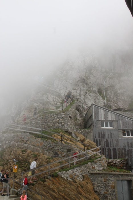 stairs climbing up the cliff but filtered by white fog or cloug