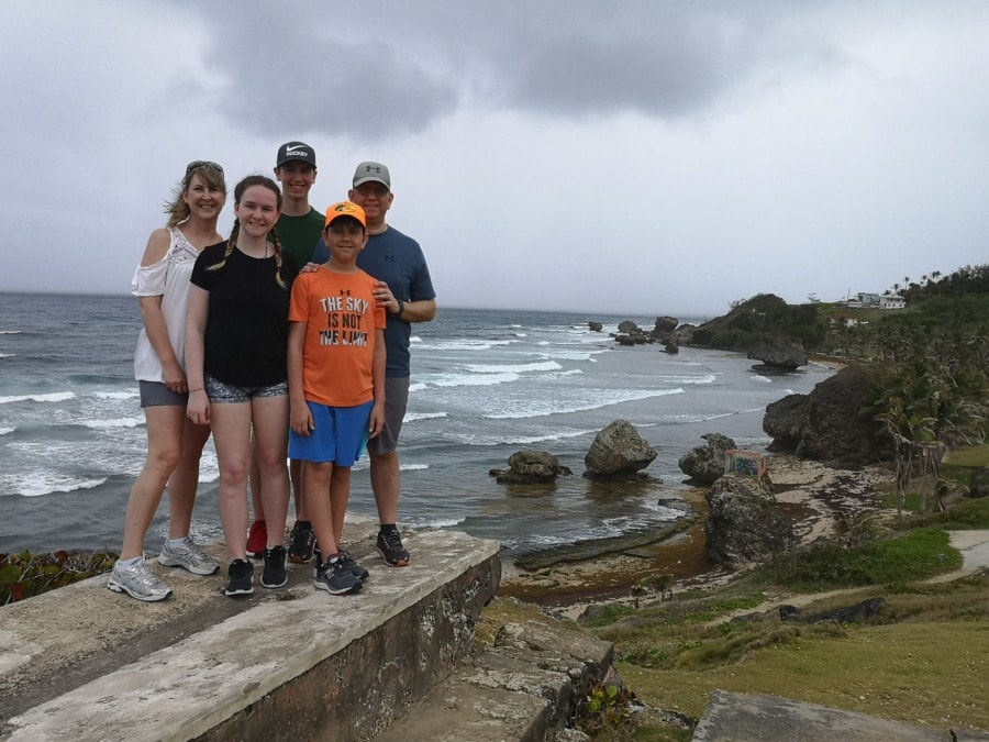 full family on rock with stunning Bathsheba rocks and waves in background is most instagrammable location in Barbados