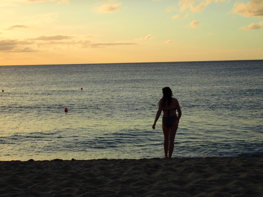 girl walking towards water on beach at sunset Barbados instagram