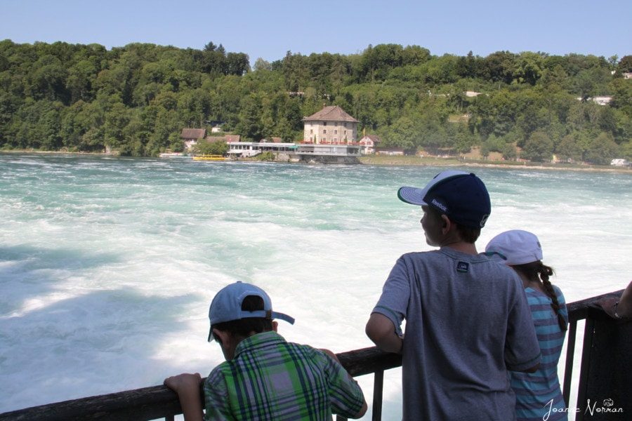 Three children looking at the basin with the water from Rheinfall lands