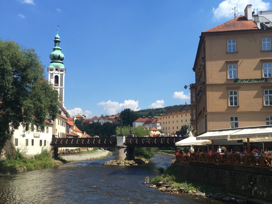 one day in cesky krumlov you have to see the Vltava River with bridge between and flowers on each side