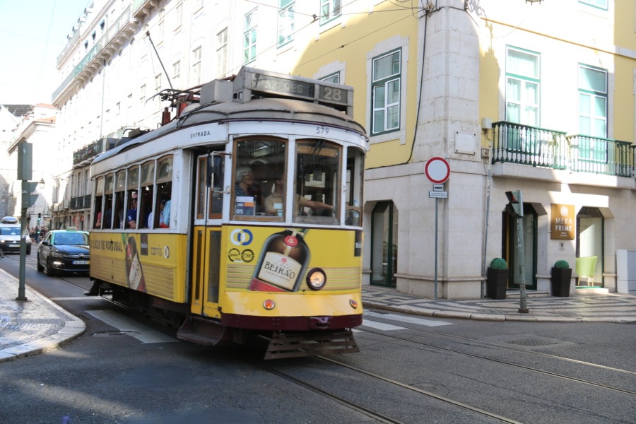 yellow tram filled with people great Lisbon with kids