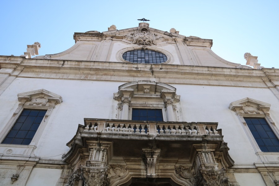 front view of white stone church with black marks Lisbon activities